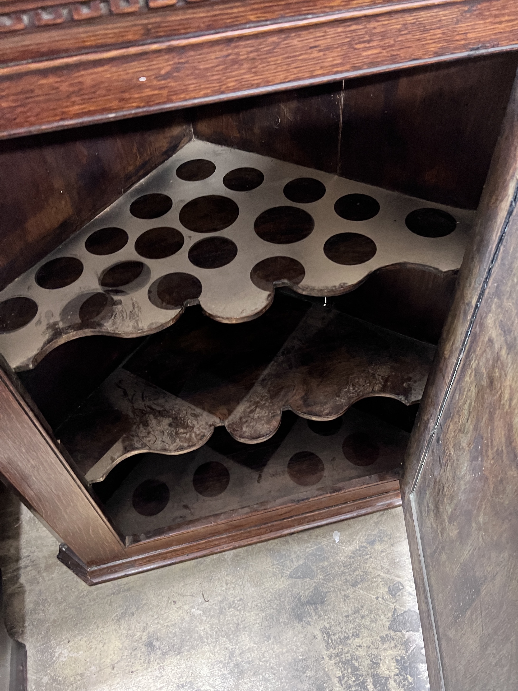 A George III oak hanging corner cabinet with serpentine shelves, width 84cm, height 91cm